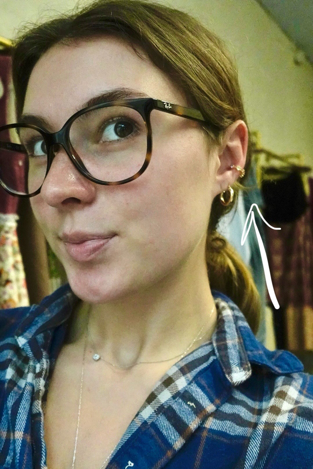 Woman wearing glasses and a plaid shirt with a blurred background