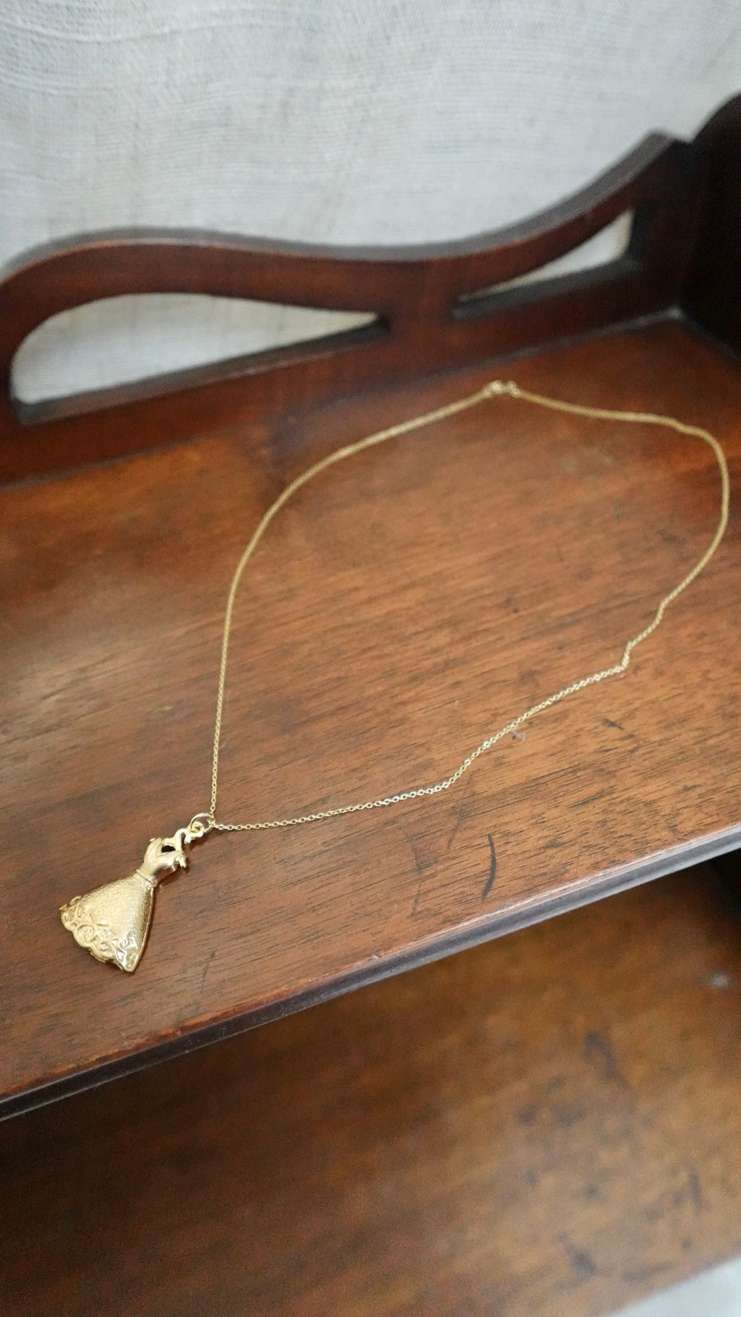 Gold necklace with a pendant on a wooden surface