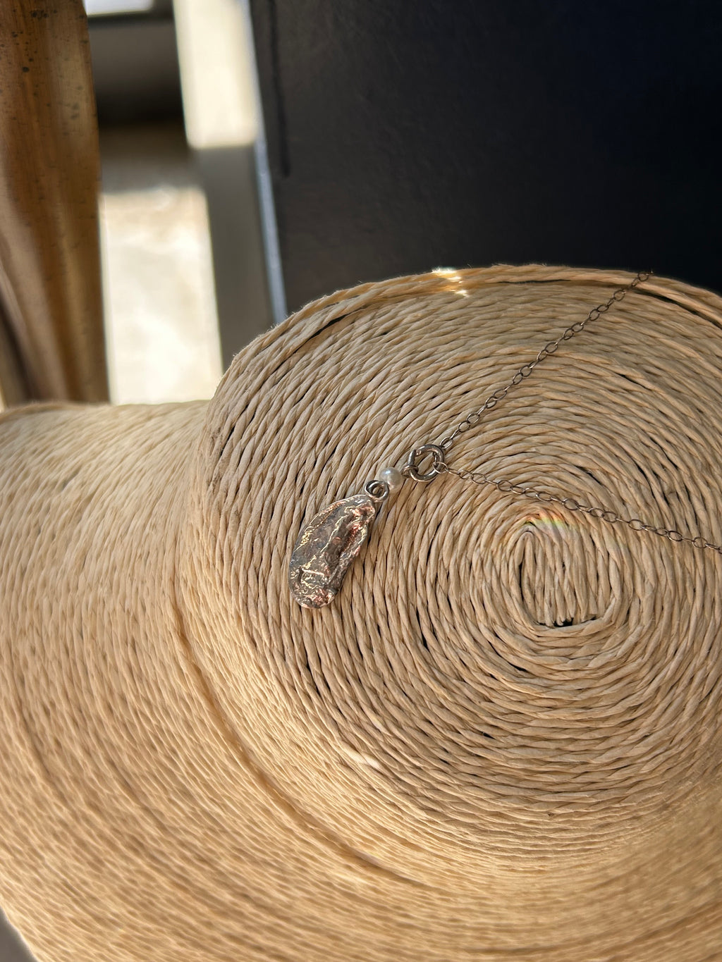 Close-up of a roll of brown paper with a bottle pendant on a dark background