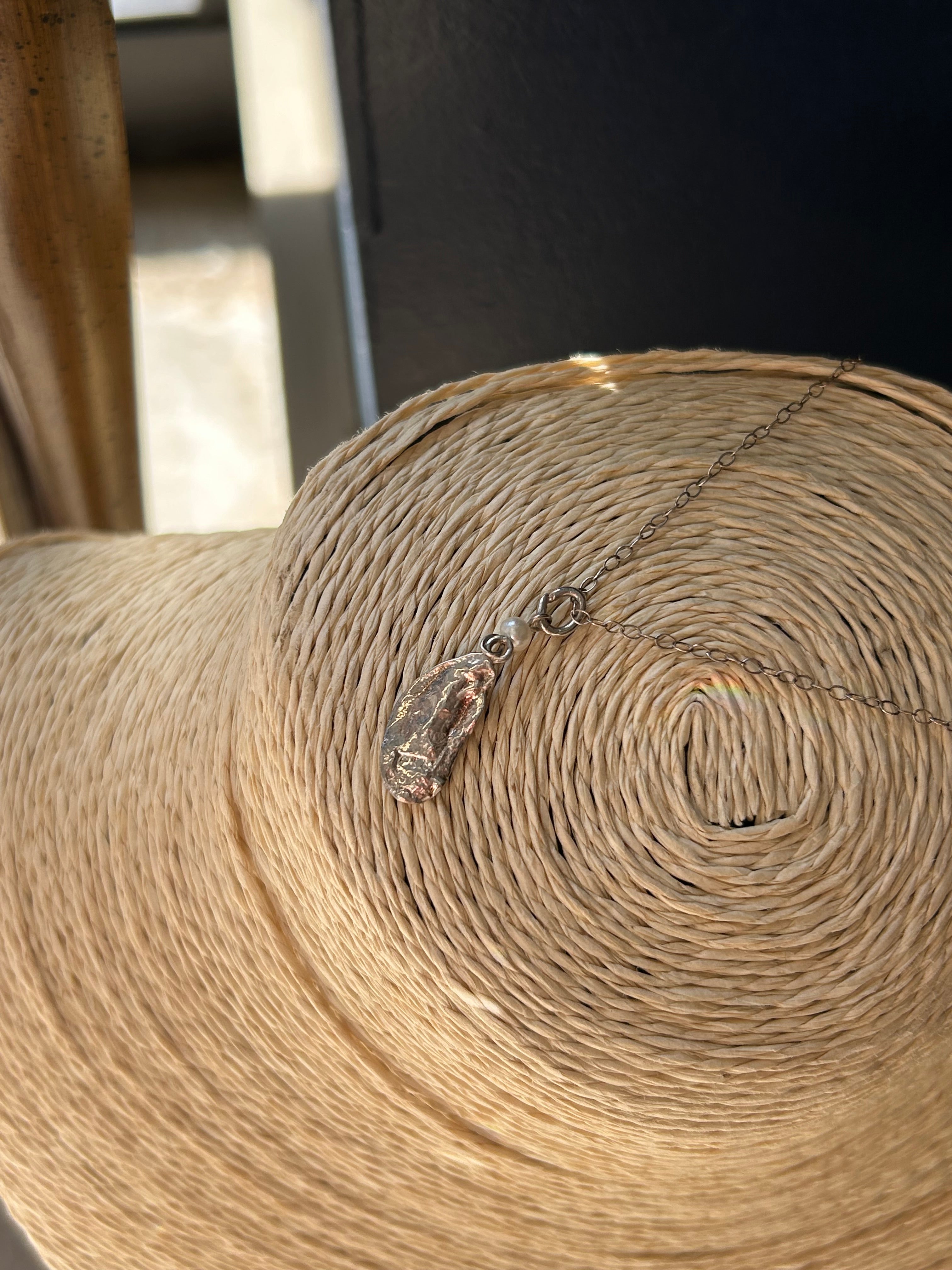Close-up of a roll of brown paper with a bottle pendant on a dark background