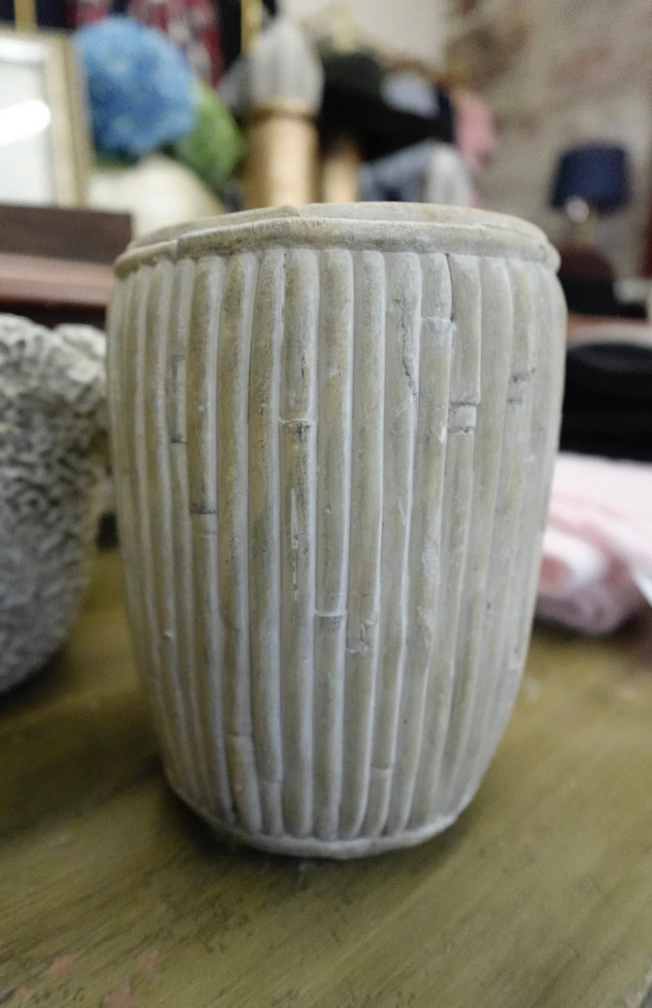 Textured ceramic vase on a wooden surface with blurred background