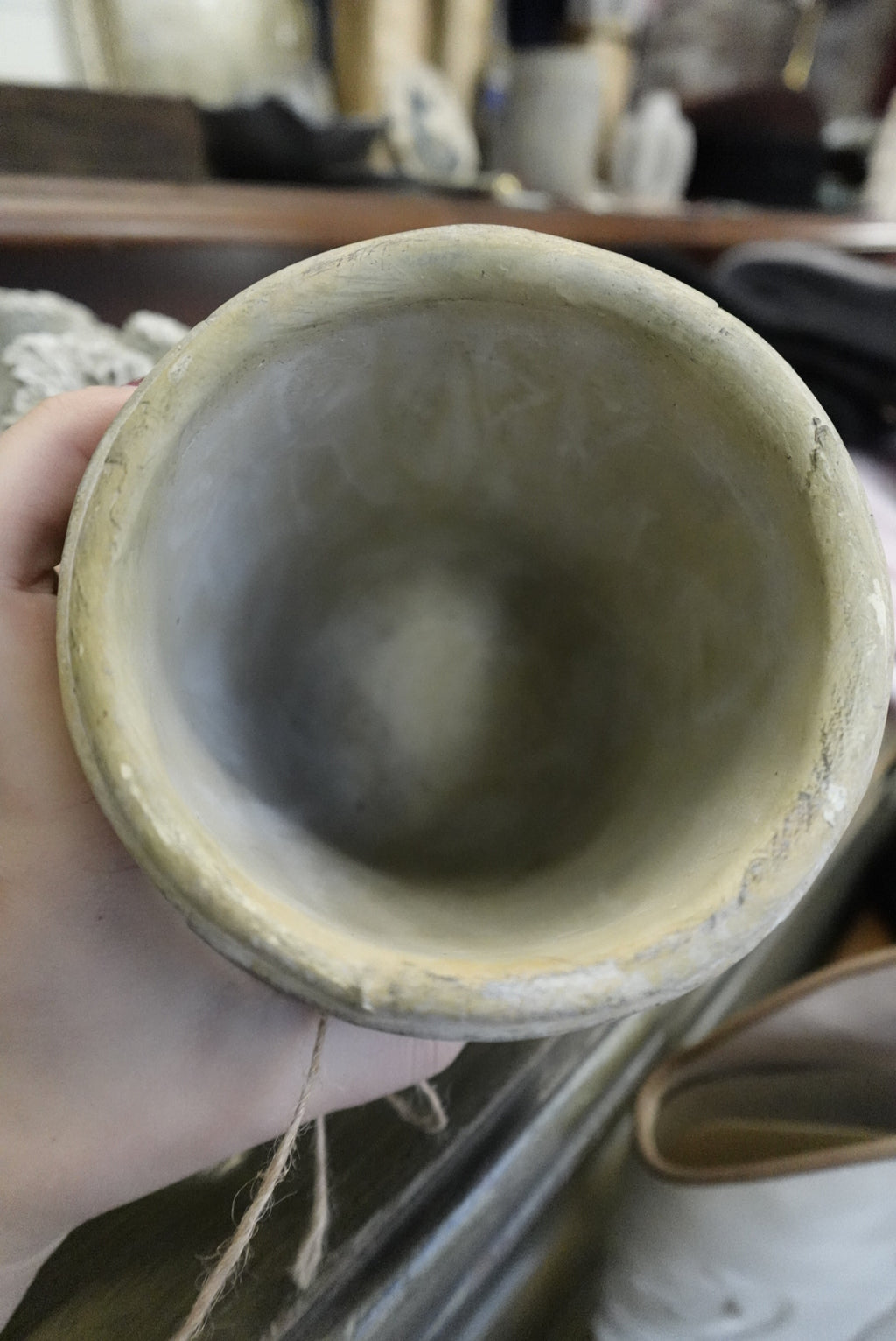 Hand holding a ceramic bowl with a blurred background