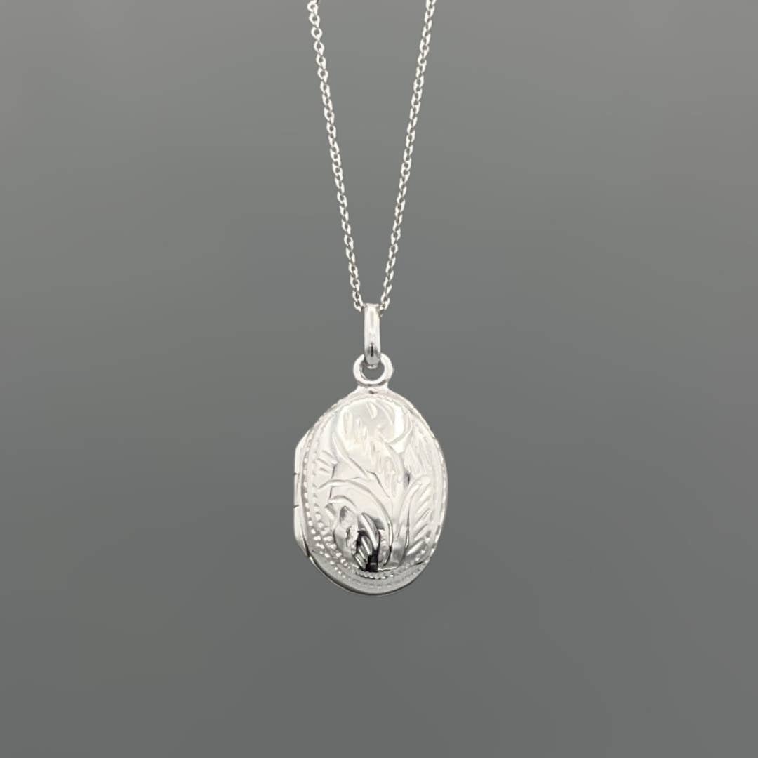 Silver locket necklace on a dark gray background