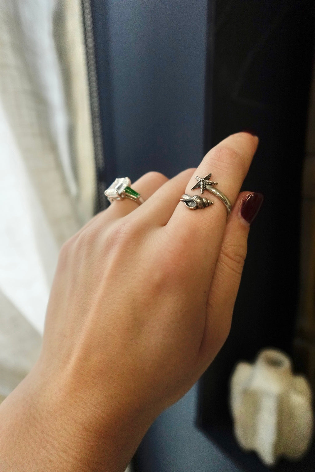 Hand wearing two rings with a blurred background