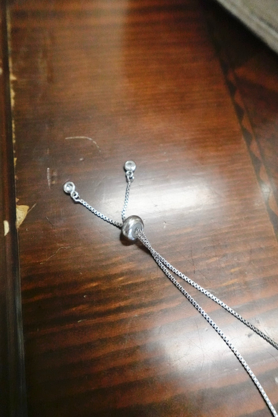 Silver necklace on a wooden surface
