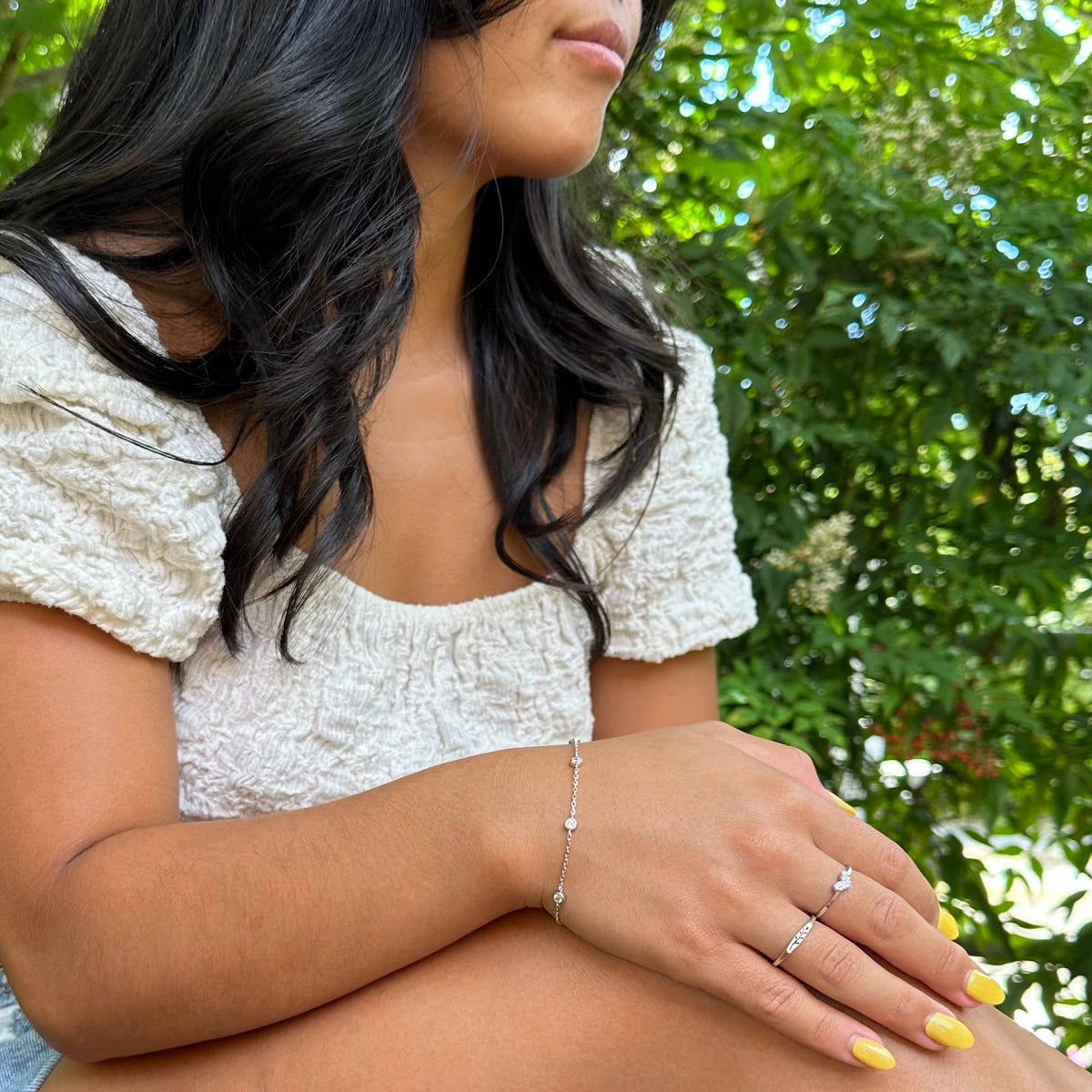 Woman in a white dress with greenery in the background