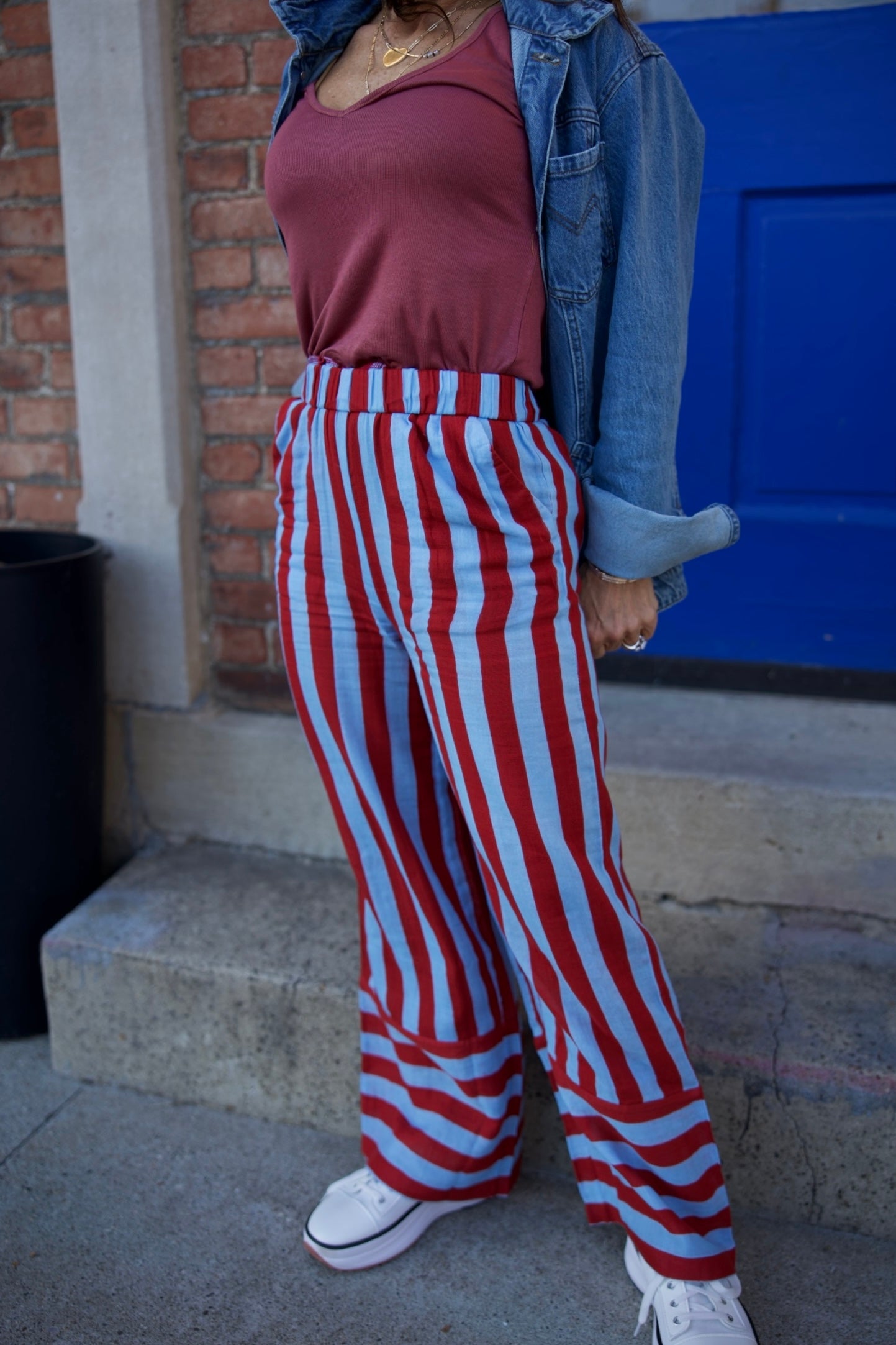 Person wearing a red and white striped outfit with a blue background