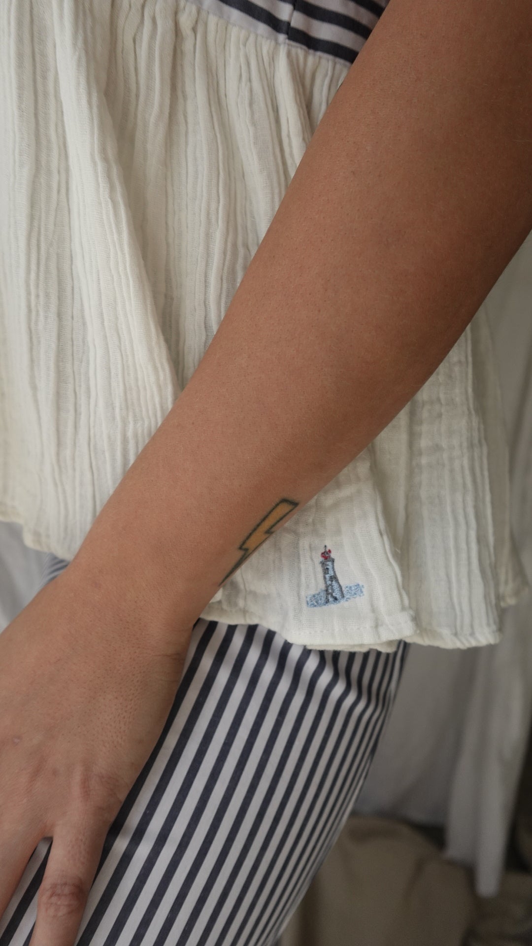Person holding a stack of white paper towels with a striped fabric background