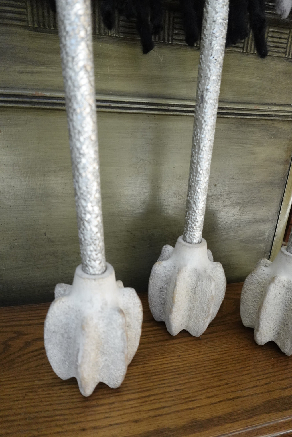 Decorative metal pole with floral designs on a wooden surface