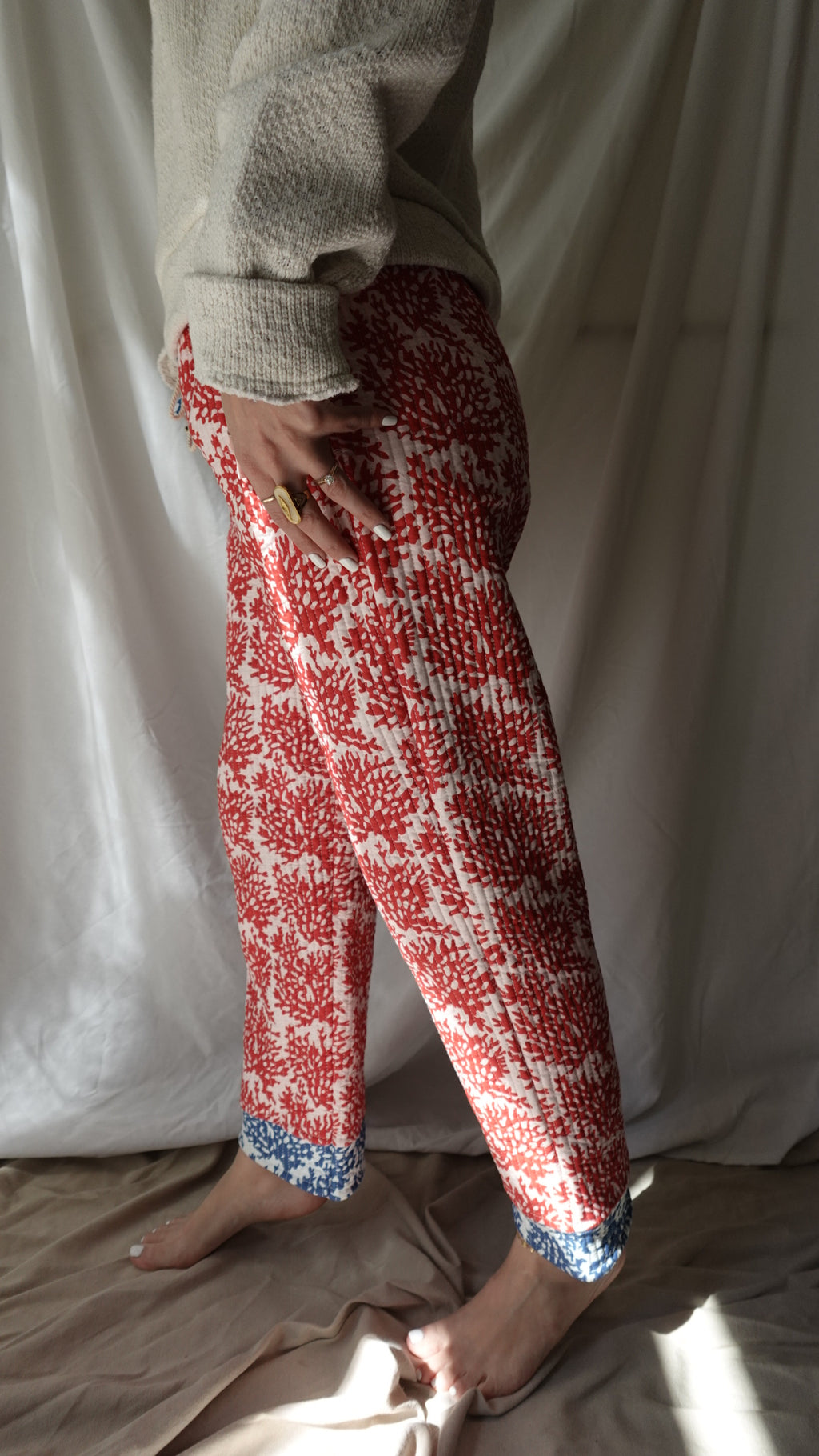 Person wearing red and white patterned leggings with blue accents on a light-colored surface.
