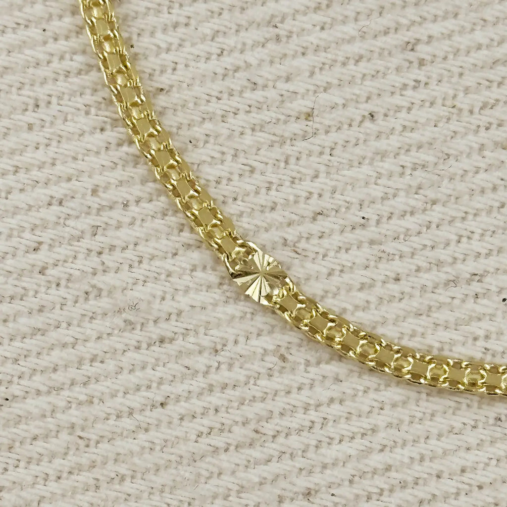 Gold chain on a textured beige background
