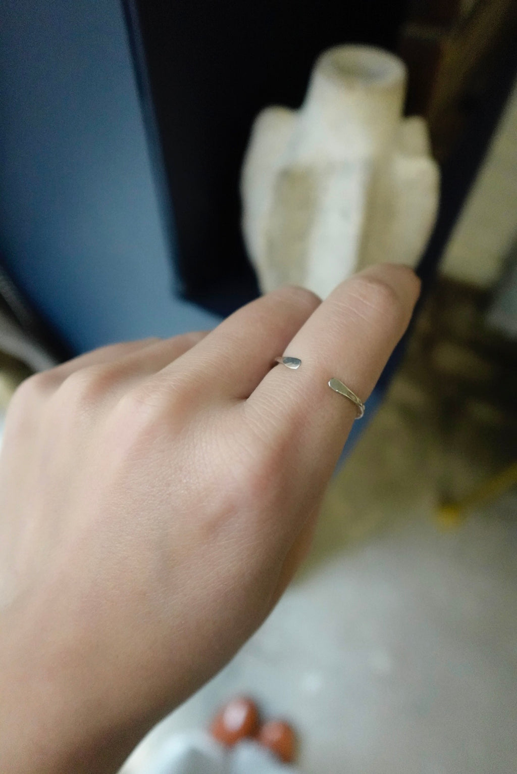 Hand wearing a gold ring with a blurred background