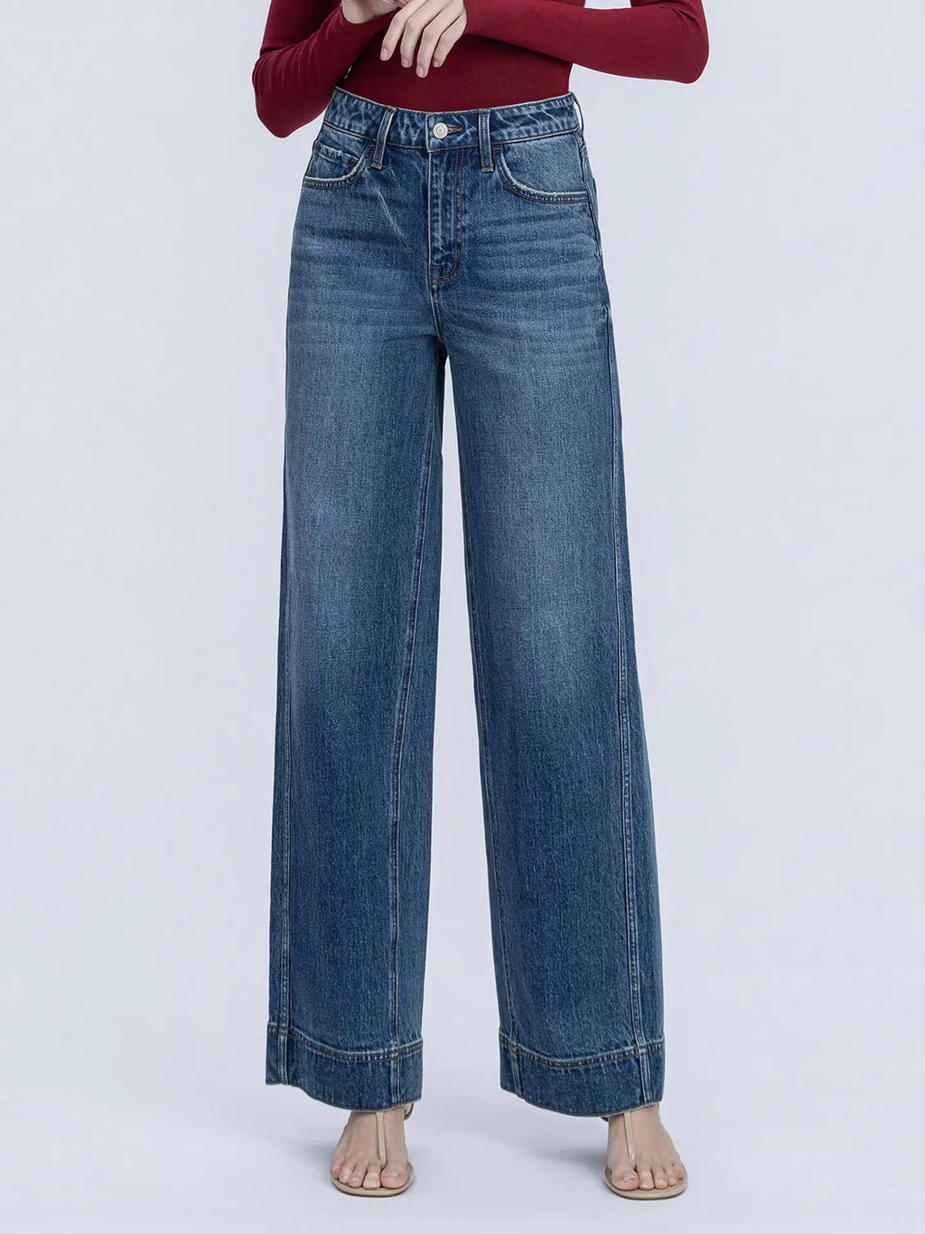 Blue jeans worn by a person on a light purple background